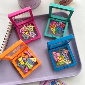 Close-up of candy-colored bone and star hair clips in vibrant PE film storage boxes