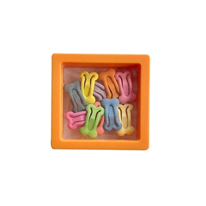 Colorful bone-shaped dog hair clips in macaron colors within an orange storage box