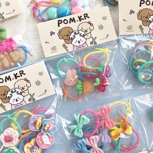 Detail of colorful children hair ties with cartoon charms in transparent packaging