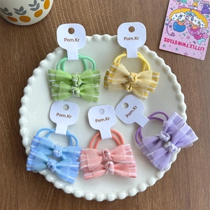 Gros plan de cinq paires de chouchous à nœuds colorés sur cartes de présentation