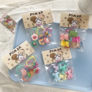 Detail of cute cartoon hair ties set with resin charms like bear and floral patterns