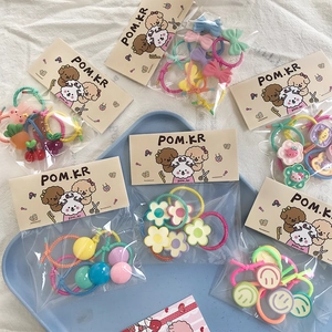 Detail view of colorful kids hair ties set with flowers and bows in cute packaging