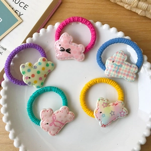 Lot de cinq chouchous lapin colorés avec motifs floraux dans un plat en céramique