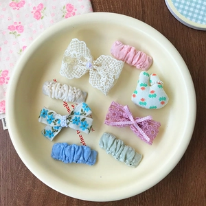 Detailed macro view of 8-piece assorted lace bow and floral pearl hair clips for kids