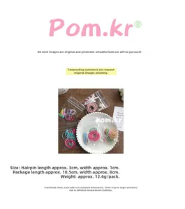 Close-up of candy color metal hair clips and elastic hair ties set in a white tray