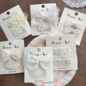 Handmade lace butterfly hair clips set with pearls on elegant white cardboard display
