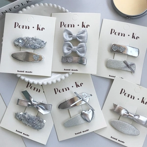 Lot de barrettes à cheveux argentées avec nœud et cœur sur carte de présentation