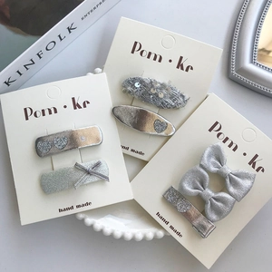 Détail de barrettes à cheveux avec cœurs et nœuds en argent, tweed et paillettes