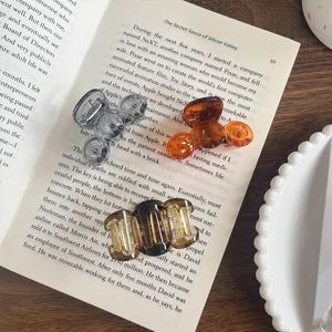 Three-piece hair claw set in transparent grey, amber orange, and tortoiseshell finish
