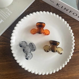 Detailed view of three mini resin shark clips in Mickey style on a white plate