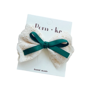 Barrette à cheveux avec dentelle, nœud en satin vert foncé et perle sur carte blanche