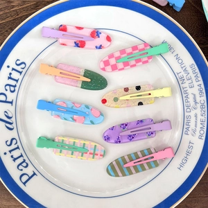 Set of 8 sweet colorful patterned seamless hair clips on a decorative white plate