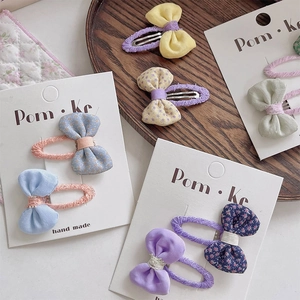 Barrettes à cheveux nœud en tissu floral pour enfants sur un plateau en bois