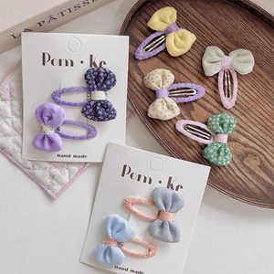 Détail de barrettes à nœuds fleuris sur un plateau en bois, style esthétique