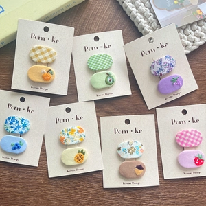 Detail of Korean floral and fruit embroidered fabric hair clips on display card