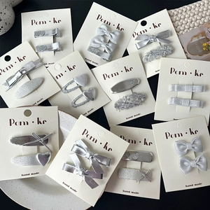 Barrettes à cheveux argentées faites main avec nœuds sur cartes de présentation
