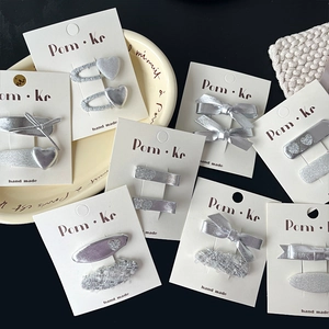 Barrettes élégantes avec nœud argenté, texture en tweed et charms cœur sur carte