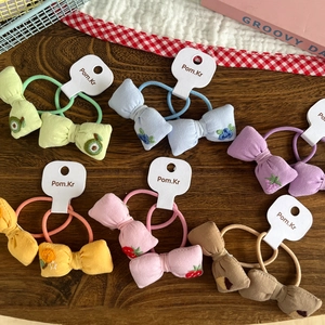 Detail of colorful children's fabric hair ties with embroidered fruit bows on card