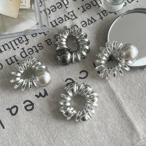 Lot de 4 élastiques spirales avec perles en argent et transparent sur fond de lin