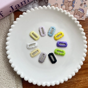 Set of 10 colorful mini woven hair clips with metal teeth arranged in a circle