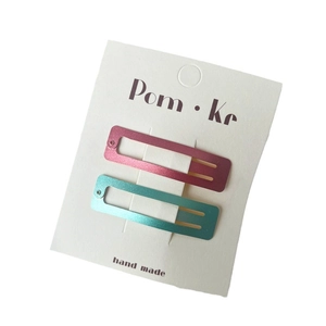 Ensemble de pinces à cheveux métalliques rose et bleu sur une carte de présentation