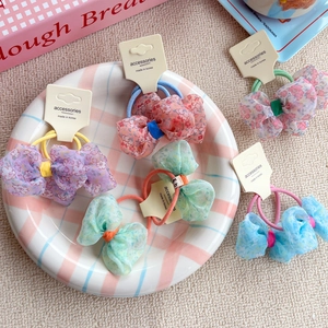 5-piece set of floral bow hair scrunchies in pastel colors on a display card