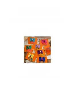 Detail view of handmade bow hair clips in various colors with pleated fabric texture