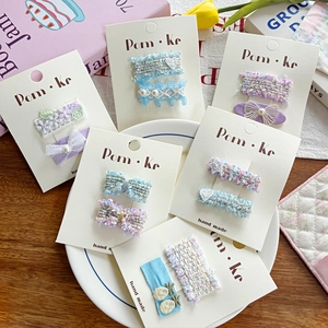 Détail de barrettes à cheveux papillon en dentelle faites main sur carte de présentation