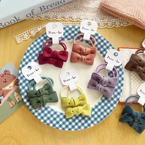 Bow fabric hair scrunchies set in various colors on a decorative vintage tray