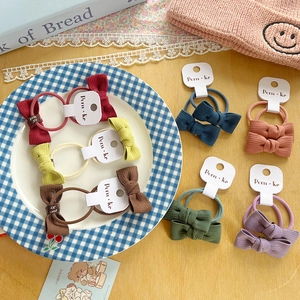 Detail view of colorful ribbed fabric bow hair ties with white hanging cards