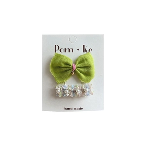 Green lace bow hair clip with bell and pearl tweed barrette set on card