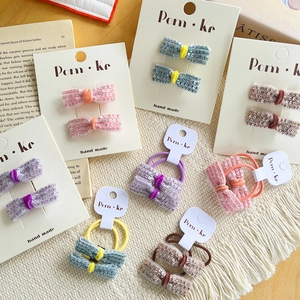 Sparkly sequin bow hair ties and clips in various colors on display card