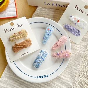 Barrettes à cheveux en dentelle et tweed aux tons pastels sur une assiette en céramique