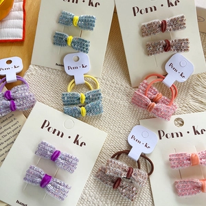 Detailed close-up of sequin bow hair clips and ties in multiple colors on cards