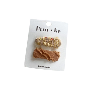 Lot de barrettes en dentelle avec paillettes brunes et texture tissu sur carte blanche
