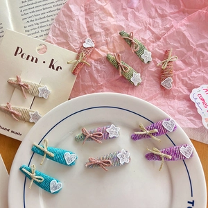 Ensemble de barrettes à nœuds et étoiles tissées colorées sur une assiette blanche