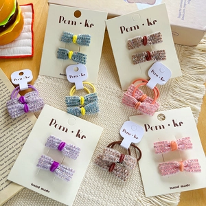 Detail showing various candy-colored sequin bow hair clips and ties on display cards