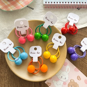 Élastiques à cheveux colorés avec perles de bonbons sur un fond de table en bois