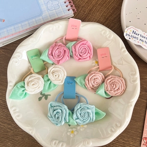 Elegant rose flower elastic hair ties in multiple colors displayed on a ceramic tray