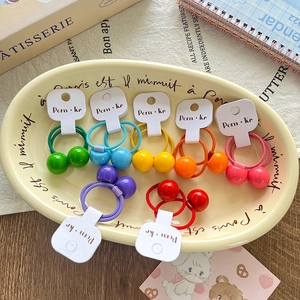 Vue détaillée d'élastiques à cheveux colorés avec boules sur un plateau décoratif