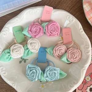 Rose flower hair scrunchies set in pink, white and blue colors on a ceramic tray