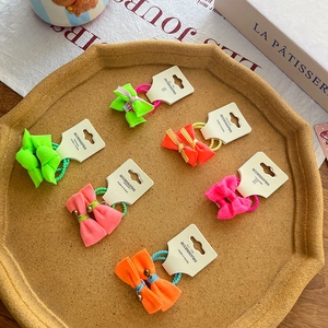 Set of 6 colorful fluorescent knotted bow hair ties on display board for girls