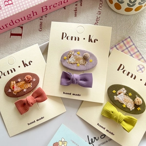 Three-piece Korean style embroidered rabbit and bow hair clips for kids on a beige card