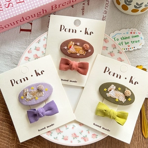 Detailed embroidery hair clips with bunny patterns and bows on display cards