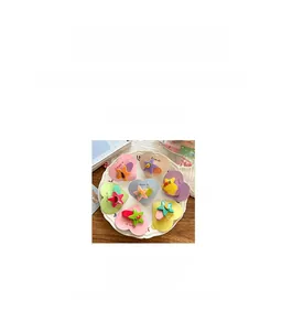Detail showing colorful cartoon star and fruit hair clips for kids on decorative card