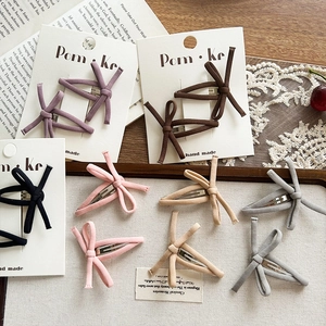 Retro fabric knot bow hair clips in multiple colors on a vintage French background