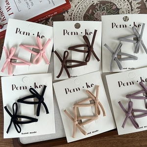 Close-up of elegant fabric bow hair clips in multiple colors on display cards