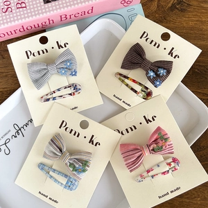 Detail of sweet bow hair clips set with floral embroidery and colorful plaid patterns