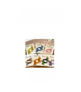 Detailed view of colorful fabric bow hair clips set with exact dimensions on card