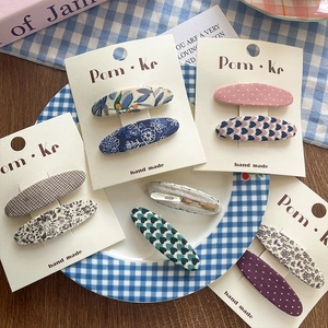 Floral and checkered fabric BB hair clips set on card display with cozy background